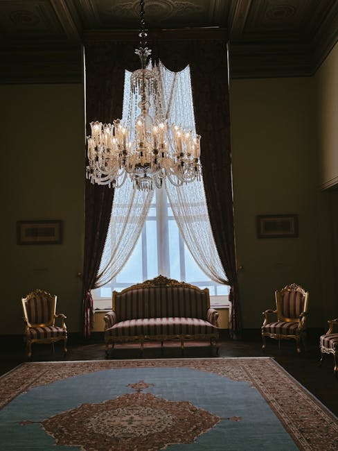 An elegant Victorian armchair made of dark polished wood with intricate carved details on the top rail, positioned on a vibrant red carpet in a room with warm, soft lighting. The chair features a curved backrest and armrests, with the seat upholstery covered in green fabric decorated with a cream-colored floral pattern, appearing clean and well-maintained. The surrounding area suggests a traditional interior setting, with a hint of a window casting light onto the chair. Notting Hill Carpet Cleaning specializes in surface cleaning and deep cleaning services, including the sanitisation of upholstery in historic homes like this, ensuring the furniture remains pristine and hygienic.